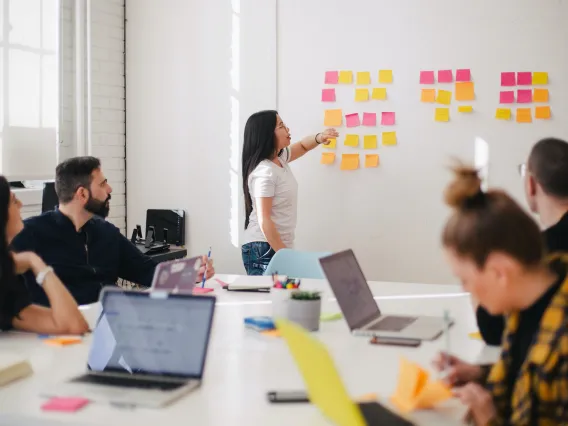 People meeting in a conference room discussing sticky notes.