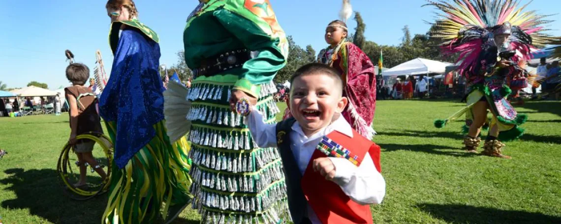 Angelina Alvarez, a Pascua Yaqui tribe member and daughter of a Vietnam veteran, wears jingle dress regalia as she and her 2-year-old son Pedro participate in the Native American Veterans Association's annual Veterans Appreciation and Heritage Day Pow Wow