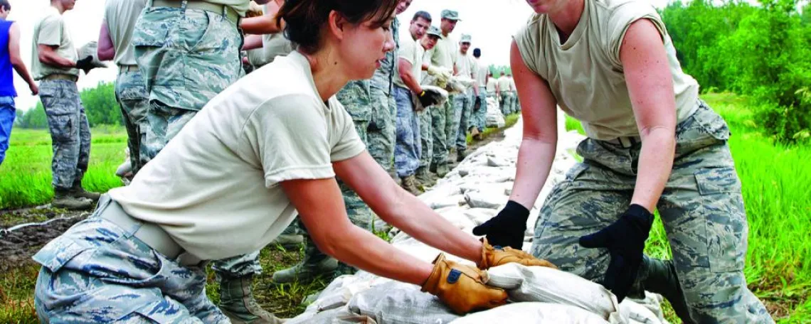 People working on a sand bag wall