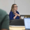 Kacey Ernst, PhD, holds her hands at her chest while talking to students.