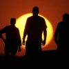 People watch the sunset from the Liberty Memorial grounds in Kansas City, Mo., May 12, 2025. (AP Photo/Charlie Riedel, File)